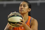 A Townsville Fire WNBL player holds the basketball as she prepares to shoot for the hoop.