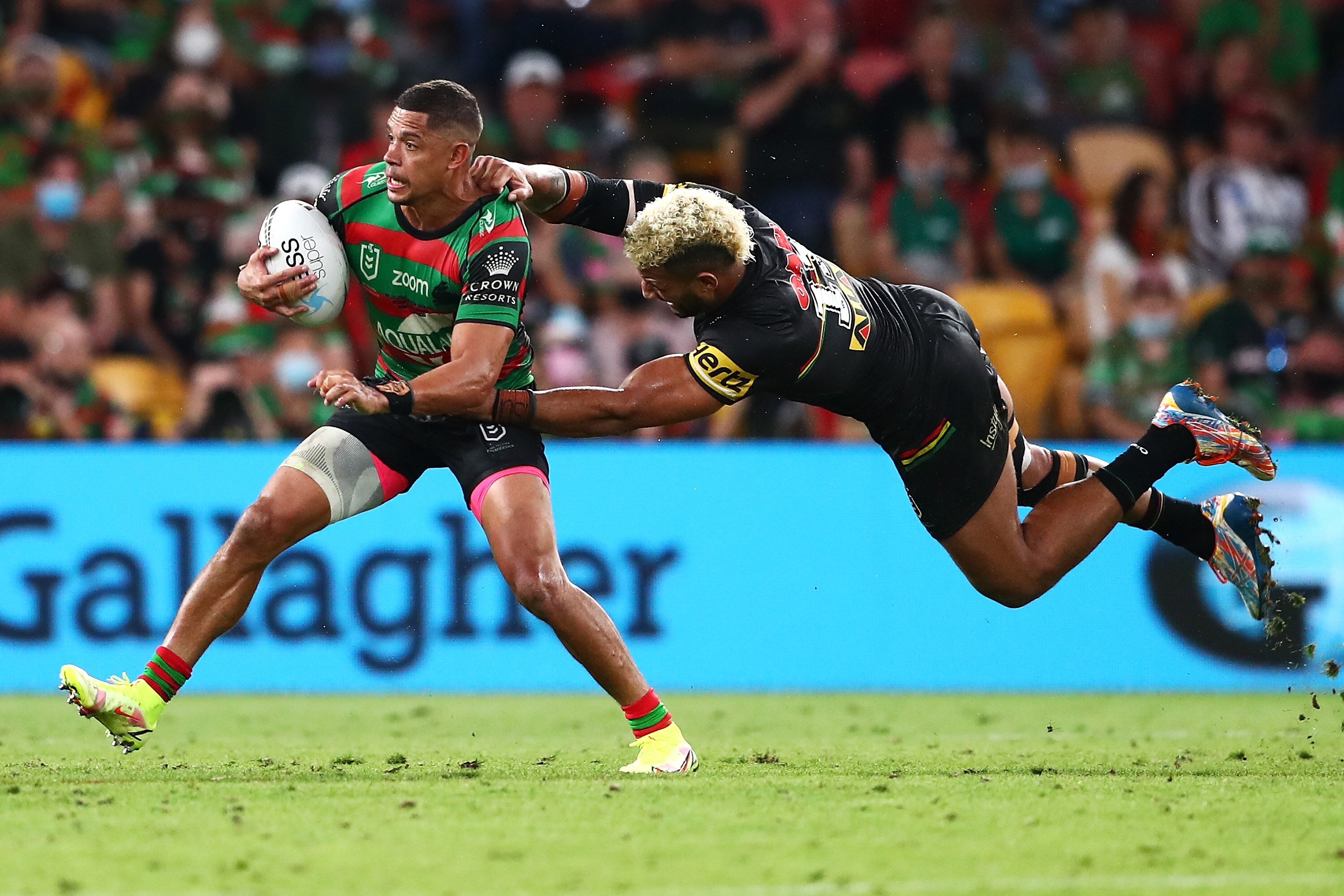 A man makes a tackle during an NRL match 
