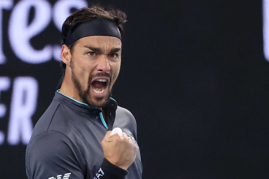 Fabio Fognini pumps his fist and yells during an Australian Open tennis match against Alex de Minaur.