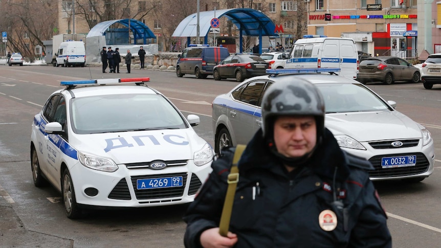 A Russian police officer stands at the site where a woman suspected of beheading a young child was detained.