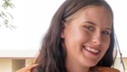 Young woman with dark brown hair and orange shirt