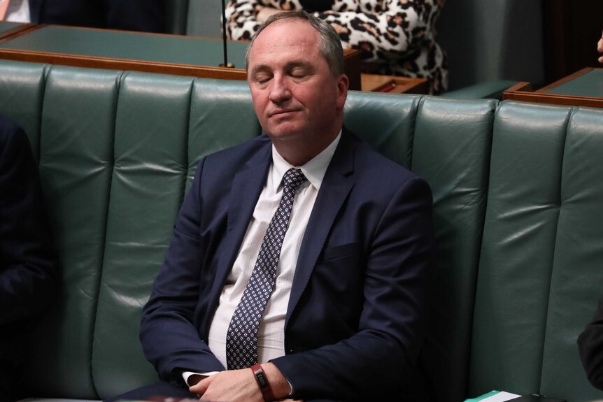 Barnaby Joyce sits with his arms folded in his lap and his eyes closed
