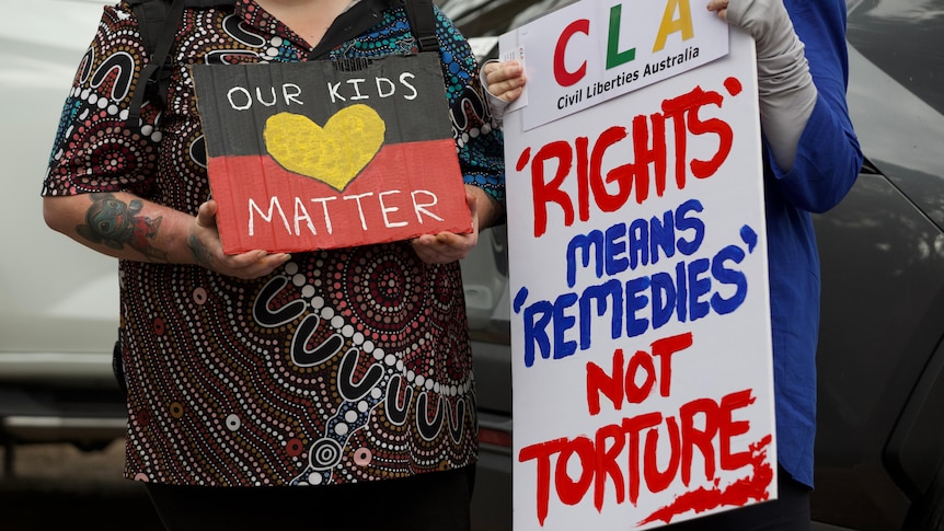 People holding signs at a rally at Banksia Hill detention centre.