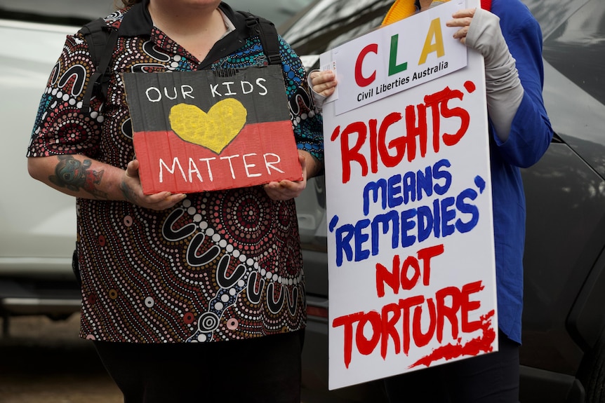 People holding signs at a rally at Banksia Hill detention centre.