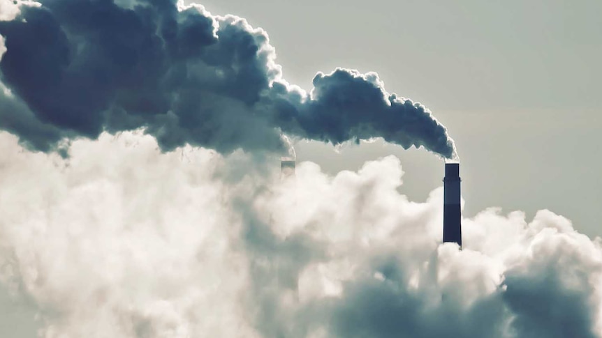 Heat, steam and smoke rising from the chimneys of a power plant.