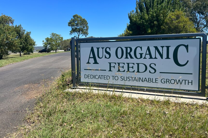 A large sign at start of driveway reads Aus Organic Feeds Dedicated to sustainable growth 