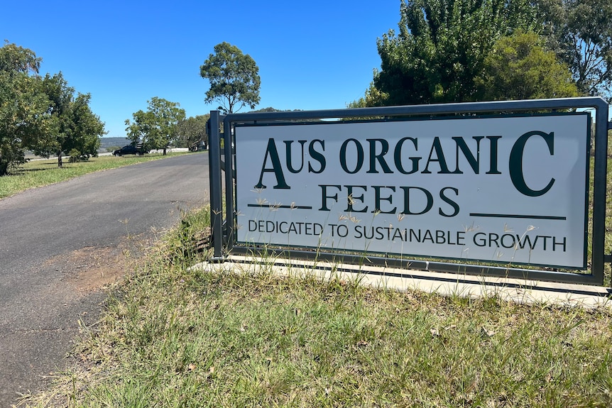 A large sign at start of driveway reads Aus Organic Feeds Dedicated to sustainable growth 