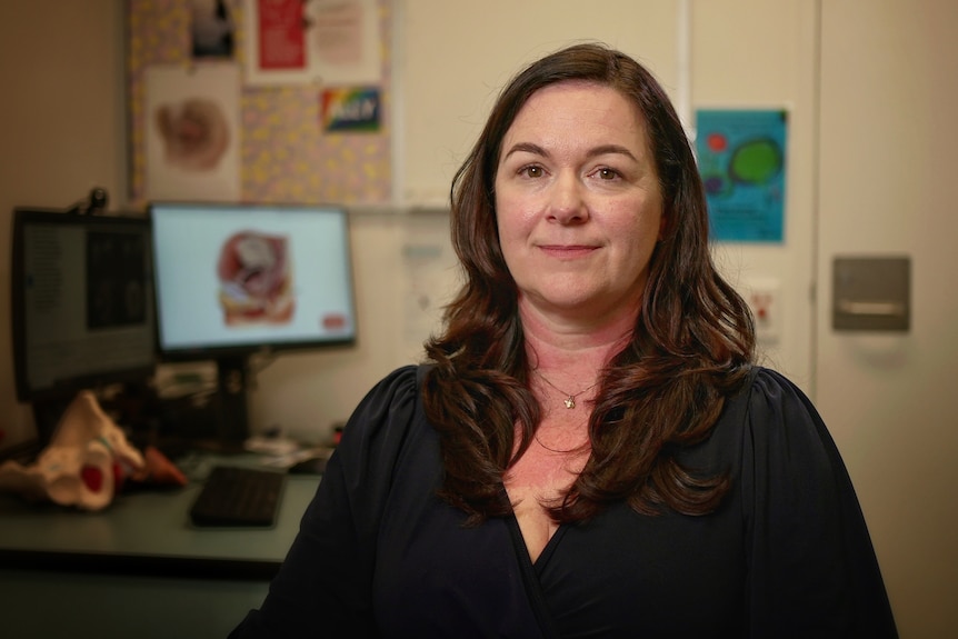 A white woman with long brown hair in a doctor's office