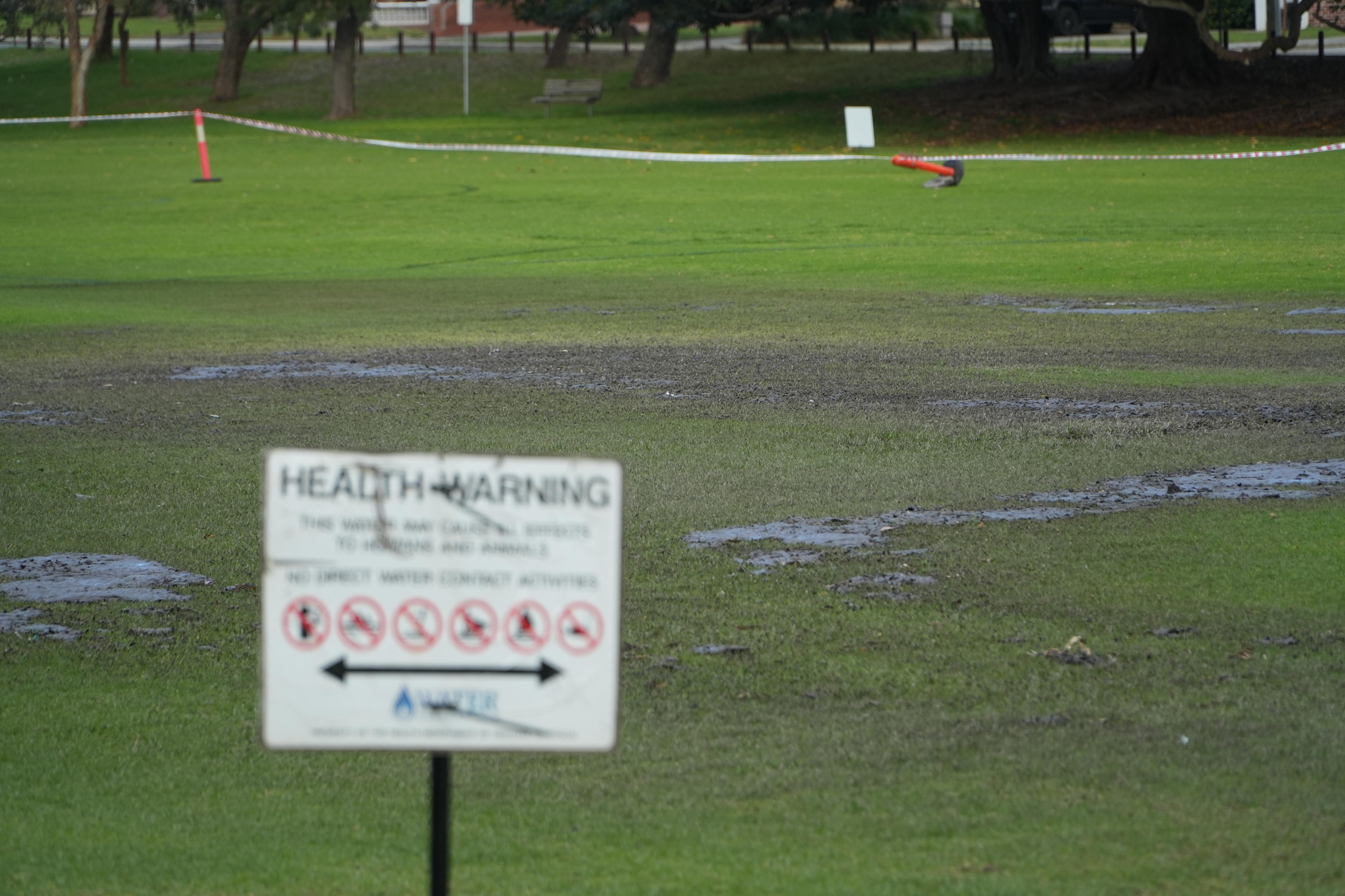 Las aguas residuales se ve en un óvalo donde se ha colocado un letrero de 'advertencia de salud'