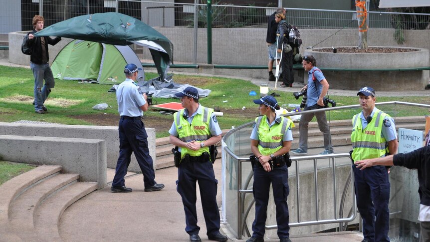 Police watch Occupy Brisbane protesters dismantle their camp.