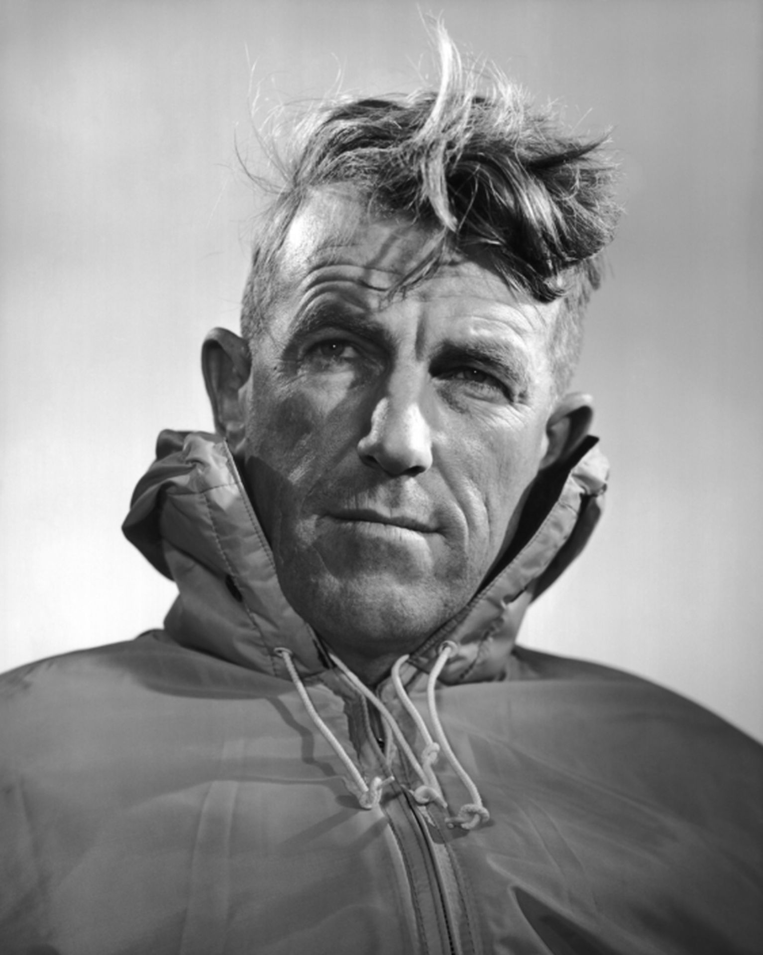 Imagem em preto e branco de Sir Edmund Hillary, de aparência séria.