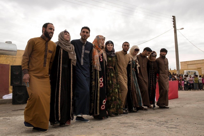 Syrian youth dancing arm in arm