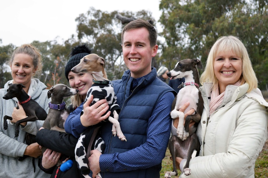 Chris Steel and three others all hold whippets and smile.