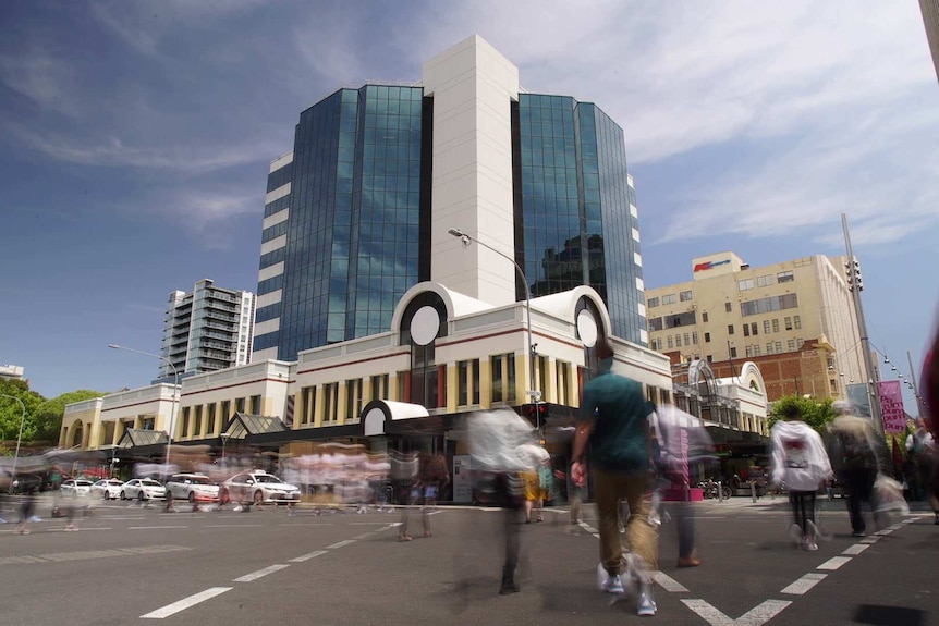 Blurred people cross a CBD intersection