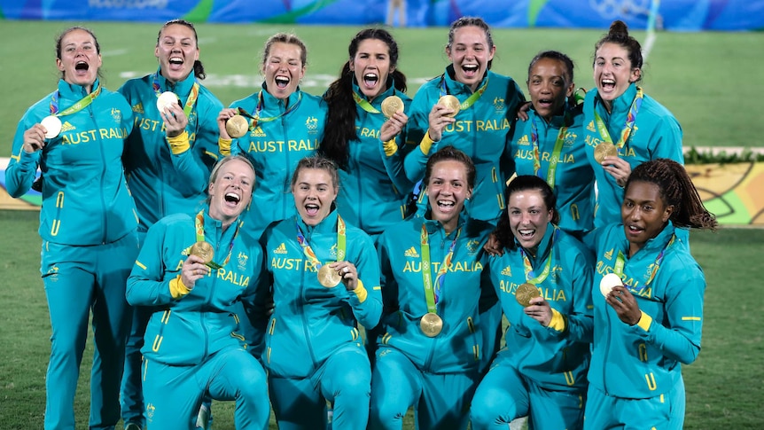 Australia's players celebrate after winning the women's rugby sevens gold medal match against New Zealand