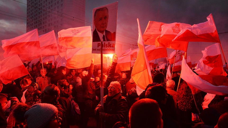 Demonstrators burn flares and wave Polish flags and signs during a far-right march in Warsaw.