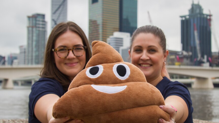Steph Young and Jemma Ambrose hold Bristol, the travelling poo.