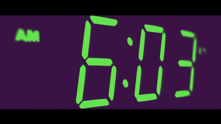 A digital clock face showing 6:03am.