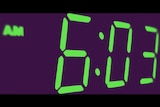A digital clock face showing 6:03am.
