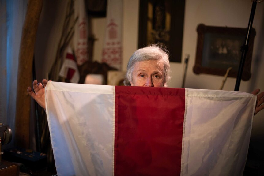 Nina Baginskaya peeks from behind a flag.