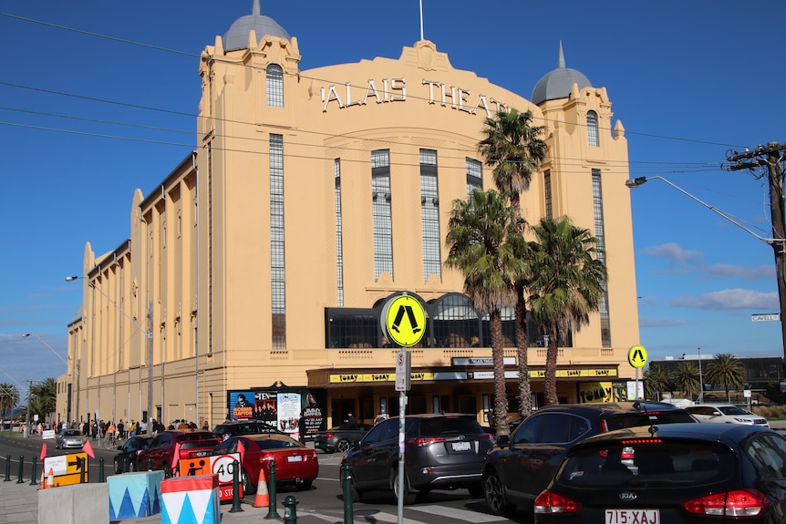 The outside of The Palais under blue skies, as cars drive past.