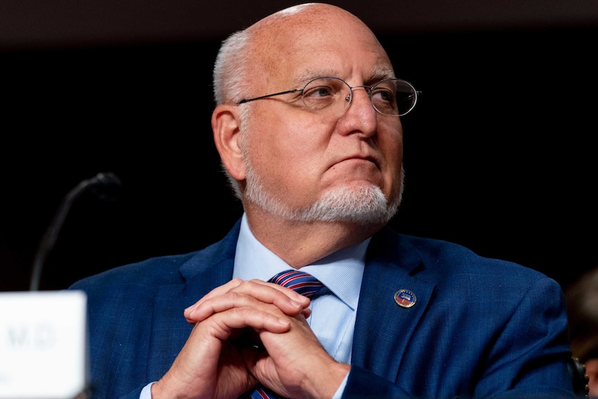 Robert Redfield sits with his hands folded