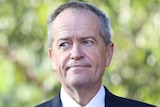 Head and shoulders shot of Bill Shorten in front of trees