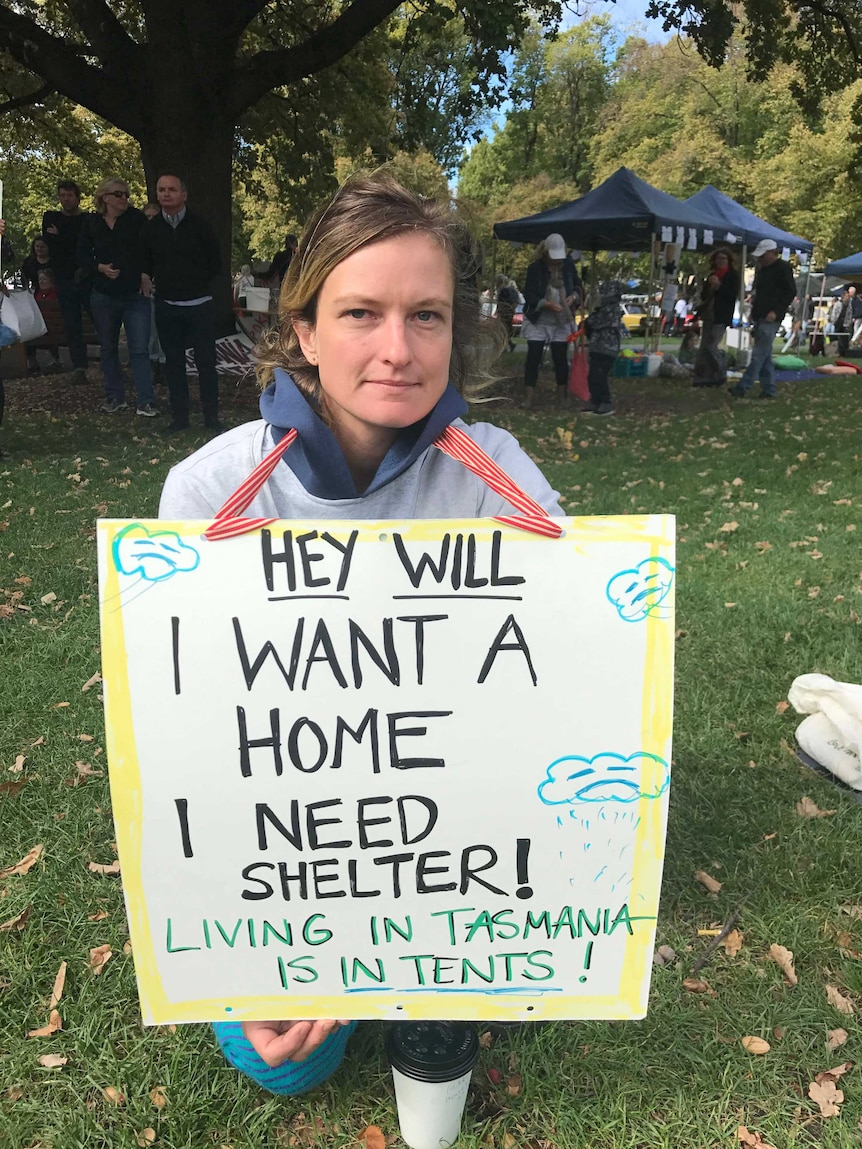 Woman holding sign for shelter.