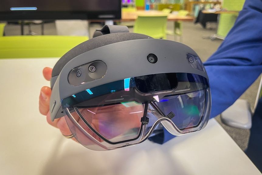A close-up of the Microsoft HoloLens, which resembles a set of shiny skiing goggles with small camera lenses in the frame.