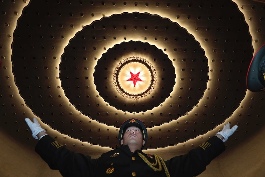 A Chinese military band conductor leads the band to rehearse ahead of the CPPCC, a red star is on the ceiling.