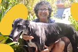 Woman with curly hair and glasses smiling at camera holding her black and white greyhound, in a story about grieving pets.