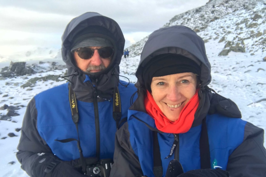 Karl Schurr and Annie McCluskey stand in cold weather gear with snow in the background.