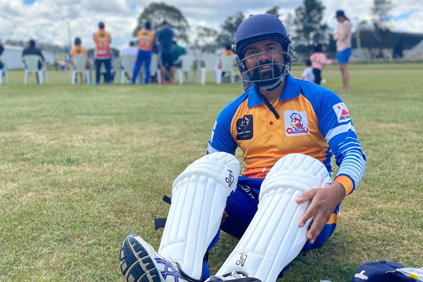 A Nepalese man in blue and orange cricket uniform