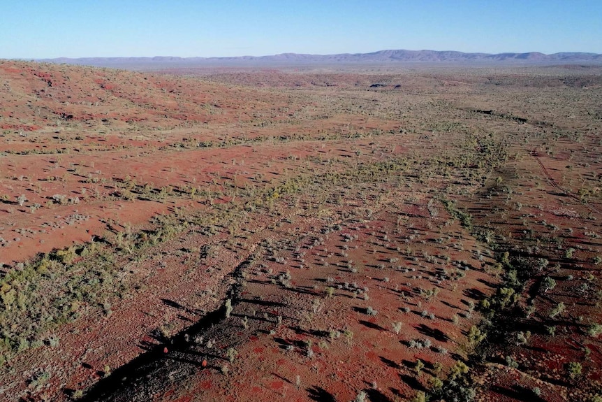 Drone landscape shot of Hamersley Range red rock mountains and green spinifex and scrub.