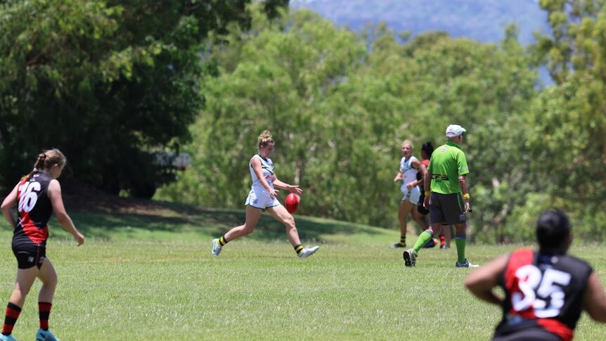 Erin Archer kicking a football in Darwin as part of a local competition.