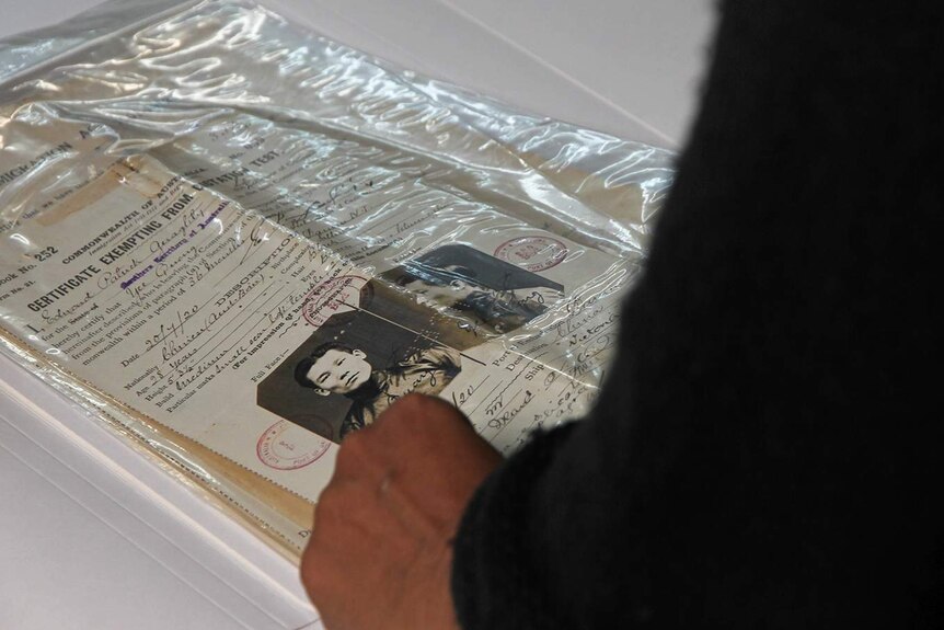 A photo of Joanne Wood standing in front of a dated certificate.