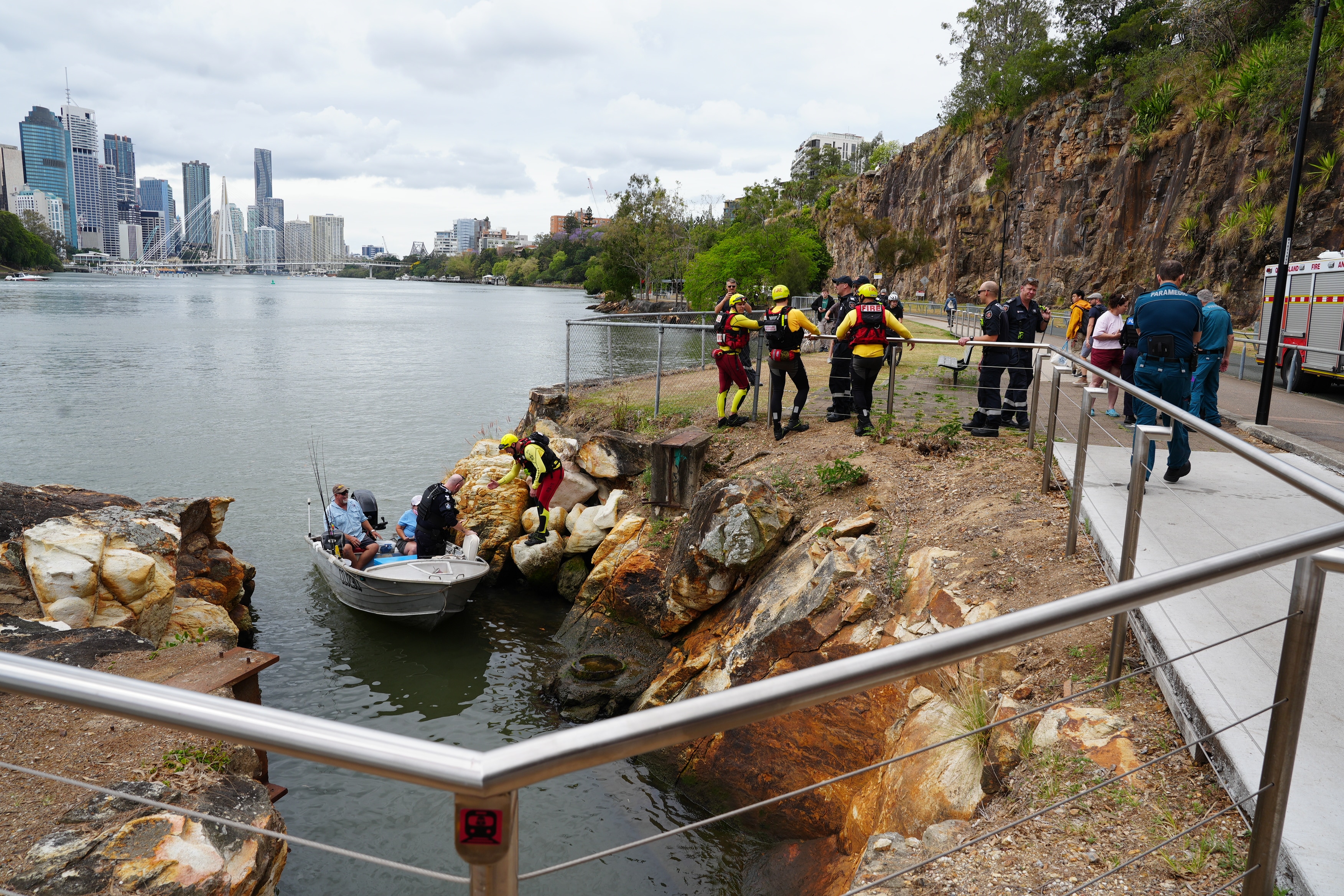 a tin boat on the brisbane river with emergency crew