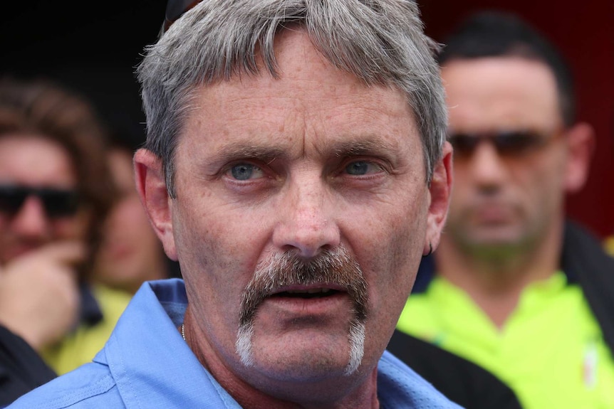 CFMEU state secretary Mick Buchan stands in front of protesting workers.