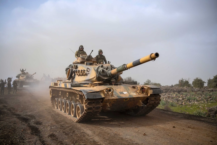 A Turkish army tank drives along a dirt road.