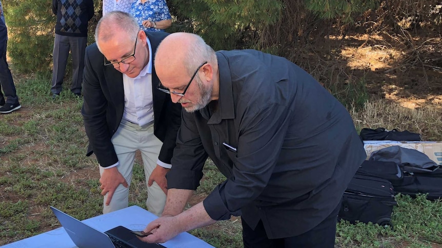 Premier Jay Weatherill and Daniel Elbaum look at a laptop screen