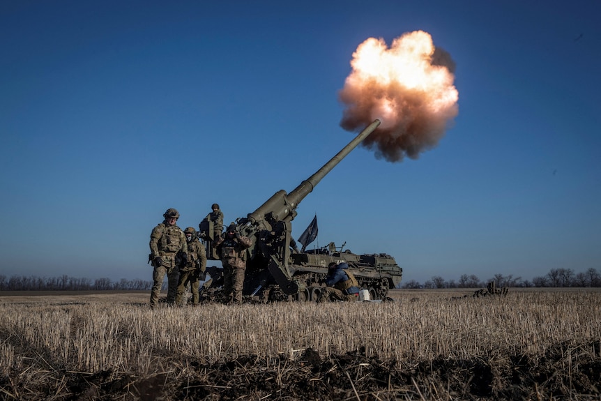 Ukrainian soldiers fire 2S7 Pion self propelled gun in a field.