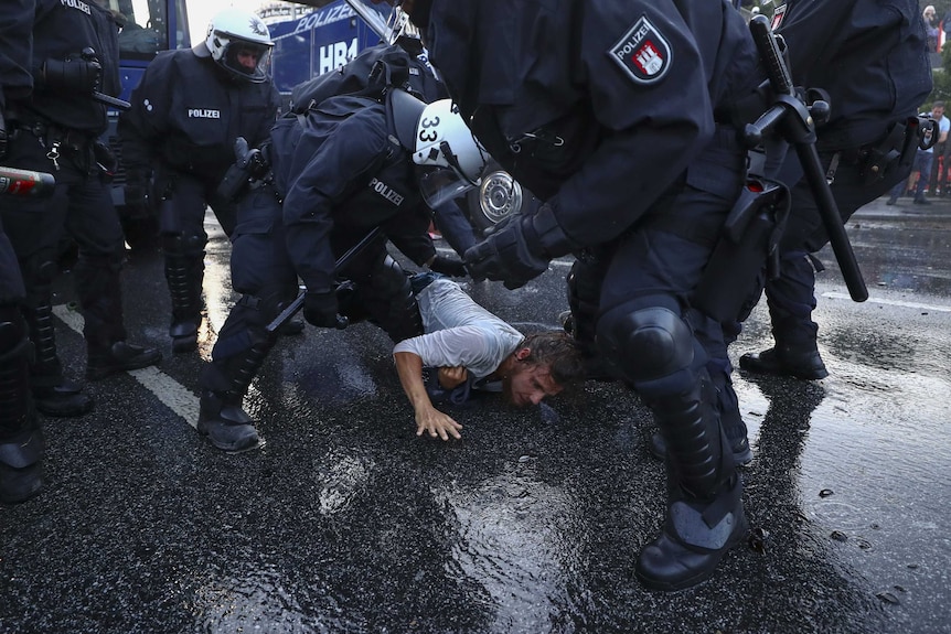 German riot police detain a man.