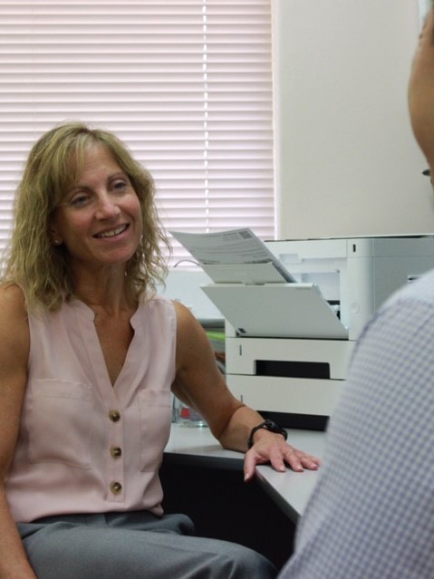 A mid shot showing Dr Nadine Perlen with a patient in a doctor's room.