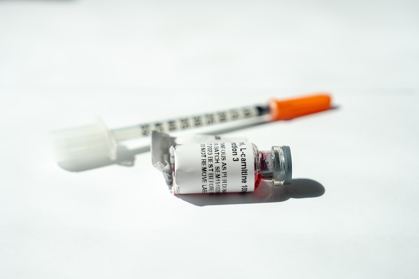 A generic image of compounded semaglutide in a small bottle, with a pharmacy label and red liquid, next to a syringe.