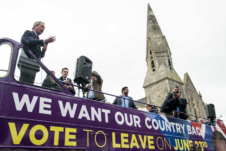 UK Independence Party leader Nigel Farage stands on a campaign bus for Brexit.