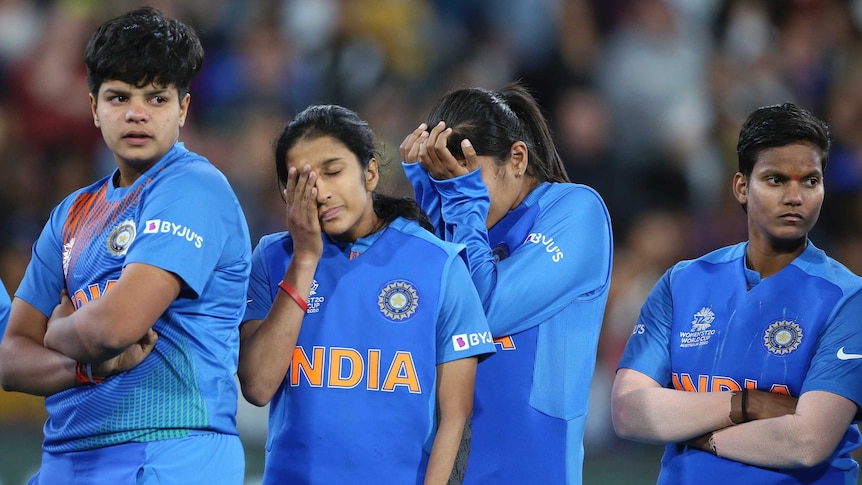 Dejected Indian women's cricketers wipe their eyes as they watch after Women's T20 World Cup final.