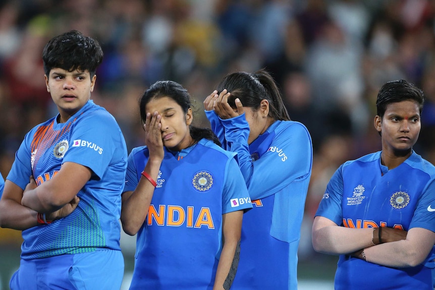 Dejected Indian women's cricketers wipe their eyes as they watch after Women's T20 World Cup final.