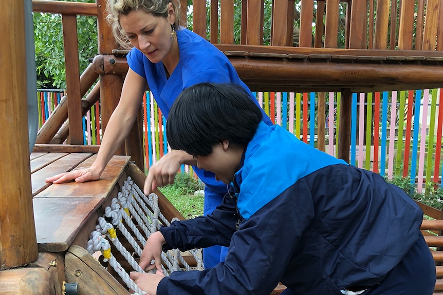 Occupational therapist helps child us rehabilitation playground at Friendship Village in Vietnam