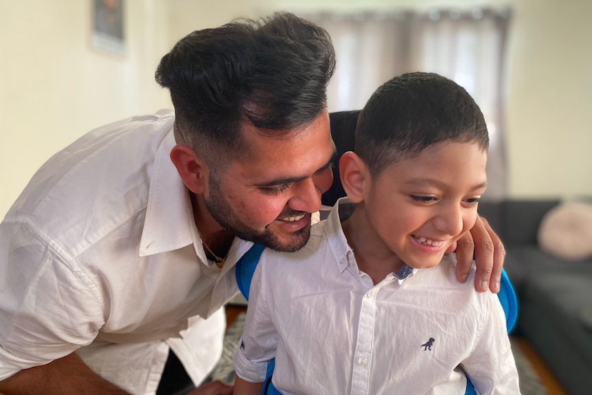 Varun Katyal has his arm around his son Kayaan's shoulder as they laugh and smile.