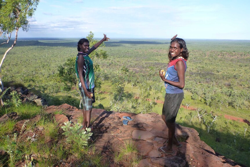 Two young women pointing over some of the 20,000 square kilometres of country looked after by the rangers